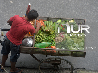 A vegetable seller arranges his van loaded with vegetables as he ferries it for sale to houses in Siliguri, India, on October 1, 2024. (