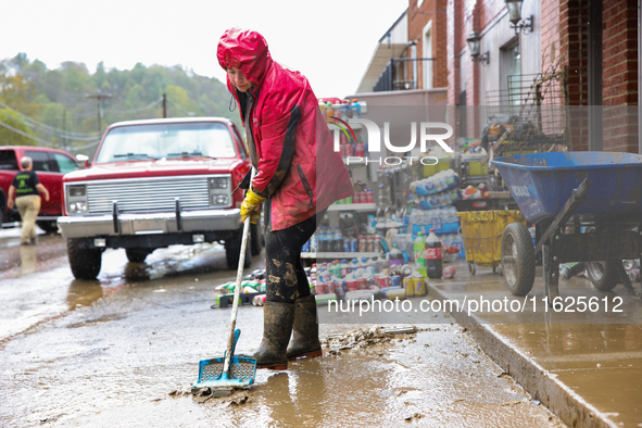 Tricia Hart, co-owner of CJ's Market in Lansing, North Carolina, cleans up storm damage on September 30, 2024 after Hurricane Helene caused...