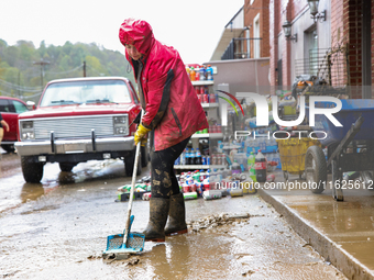 Tricia Hart, co-owner of CJ's Market in Lansing, North Carolina, cleans up storm damage on September 30, 2024 after Hurricane Helene caused...