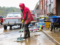 Tricia Hart, co-owner of CJ's Market in Lansing, North Carolina, cleans up storm damage on September 30, 2024 after Hurricane Helene caused...