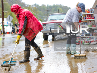 Tricia Hart, co-owner of CJ's Market in Lansing, North Carolina, cleans up storm damage on September 30, 2024 after Hurricane Helene caused...