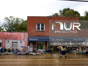 A volunteer helps clean up storm damage at CJ's Market in Lansing, North Carolina on September 30, 2024 after Hurricane Helene caused widesp...