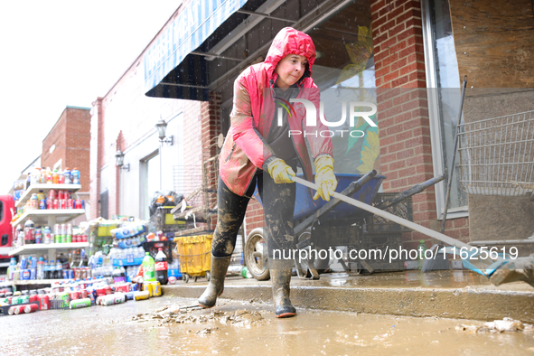 Tricia Hart, co-owner of CJ's Market in Lansing, North Carolina, cleans up storm damage on September 30, 2024 after Hurricane Helene caused...