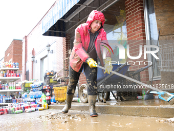 Tricia Hart, co-owner of CJ's Market in Lansing, North Carolina, cleans up storm damage on September 30, 2024 after Hurricane Helene caused...