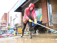 Tricia Hart, co-owner of CJ's Market in Lansing, North Carolina, cleans up storm damage on September 30, 2024 after Hurricane Helene caused...