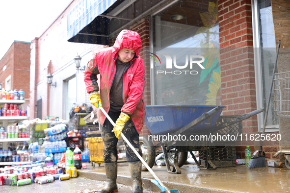 Tricia Hart, co-owner of CJ's Market in Lansing, North Carolina, cleans up storm damage on September 30, 2024 after Hurricane Helene caused...