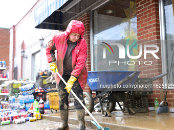 Tricia Hart, co-owner of CJ's Market in Lansing, North Carolina, cleans up storm damage on September 30, 2024 after Hurricane Helene caused...