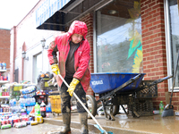 Tricia Hart, co-owner of CJ's Market in Lansing, North Carolina, cleans up storm damage on September 30, 2024 after Hurricane Helene caused...