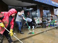 Tricia Hart, co-owner of CJ's Market in Lansing, North Carolina, left in pink, cleans up storm damage on September 30, 2024 after Hurricane...