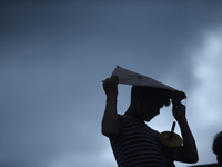 A silhouette view of a young boy flying a kite on the roof of a house in Kirtipur, Kathmandu, Nepal, on September 15, 2024. People fly kites...