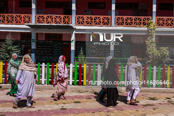 Women walk to cast their votes in the third phase of Assembly elections in Handwara, Jammu and Kashmir, India, on October 1, 2024. 