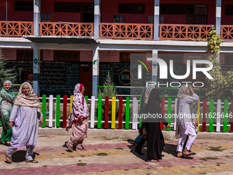 Women walk to cast their votes in the third phase of Assembly elections in Handwara, Jammu and Kashmir, India, on October 1, 2024. (