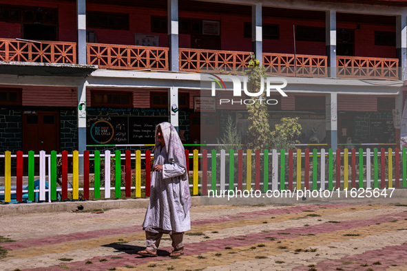 A woman walks after casting her vote in the third phase of Assembly elections in Handwara, Jammu and Kashmir, India, on October 1, 2024. 