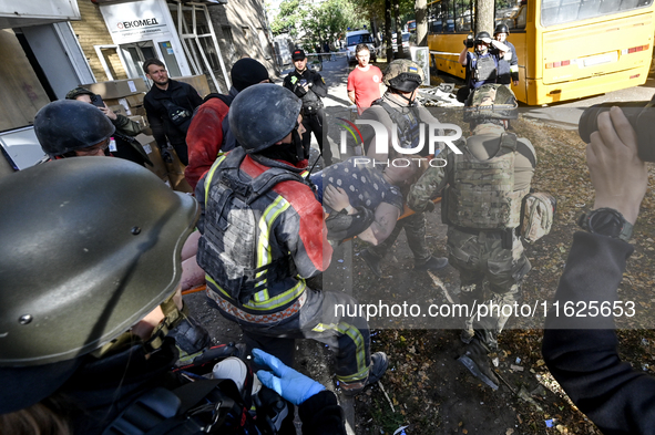 Rescuers carry a local resident, Yuliia, who is freed from the rubble of a multi-storey residential building damaged by a Russian KAB, to an...