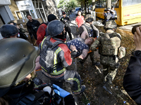 Rescuers carry a local resident, Yuliia, who is freed from the rubble of a multi-storey residential building damaged by a Russian KAB, to an...