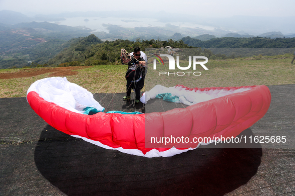 A paragliding athlete prepares to take part in a paragliding competition in Sumedang, Indonesia, on October 1, 2024. The paragliding competi...