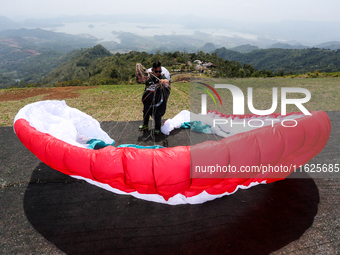 A paragliding athlete prepares to take part in a paragliding competition in Sumedang, Indonesia, on October 1, 2024. The paragliding competi...