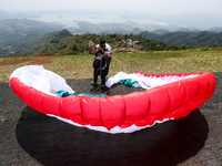 A paragliding athlete prepares to take part in a paragliding competition in Sumedang, Indonesia, on October 1, 2024. The paragliding competi...