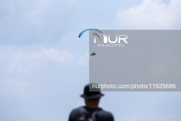 A paragliding athlete takes part in a paragliding competition in Sumedang, Indonesia, on October 1, 2024. Various athletes from countries in...