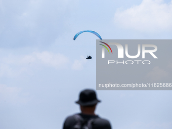 A paragliding athlete takes part in a paragliding competition in Sumedang, Indonesia, on October 1, 2024. Various athletes from countries in...