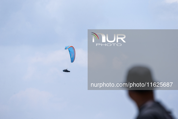 A paragliding athlete takes part in a paragliding competition in Sumedang, Indonesia, on October 1, 2024. Various athletes from countries in...