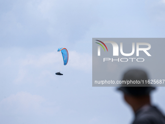 A paragliding athlete takes part in a paragliding competition in Sumedang, Indonesia, on October 1, 2024. Various athletes from countries in...