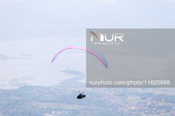 A paragliding athlete takes part in a paragliding competition in Sumedang, Indonesia, on October 1, 2024. Various athletes from countries in...