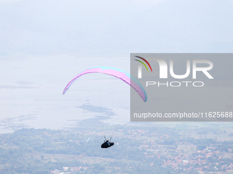 A paragliding athlete takes part in a paragliding competition in Sumedang, Indonesia, on October 1, 2024. Various athletes from countries in...