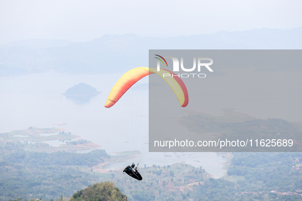 A paragliding athlete takes part in a paragliding competition in Sumedang, Indonesia, on October 1, 2024. Various athletes from countries in...