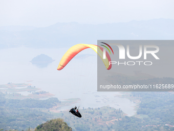 A paragliding athlete takes part in a paragliding competition in Sumedang, Indonesia, on October 1, 2024. Various athletes from countries in...