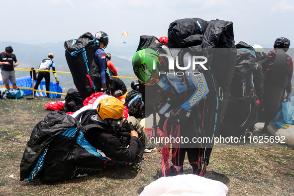 A number of paragliding athletes prepare to take part in a paragliding competition in Sumedang, Indonesia, on October 1, 2024. The paraglidi...