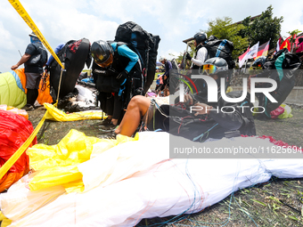 A number of paragliding athletes prepare to take part in a paragliding competition in Sumedang, Indonesia, on October 1, 2024. The paraglidi...