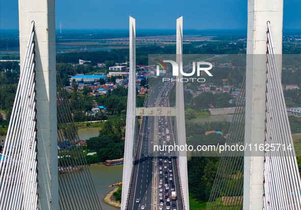 A large number of vehicles move slowly along an expressway in Huai'an, China, on October 1, 2024. 