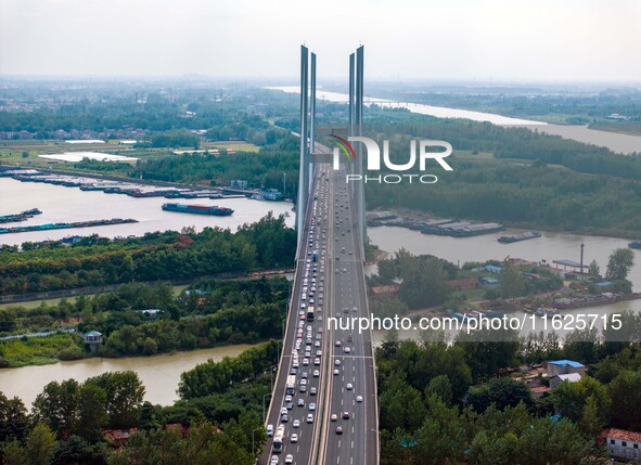 A large number of vehicles move slowly along an expressway in Huai'an, China, on October 1, 2024. 