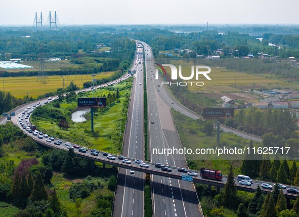 A large number of vehicles move slowly along an expressway in Huai'an, China, on October 1, 2024. 