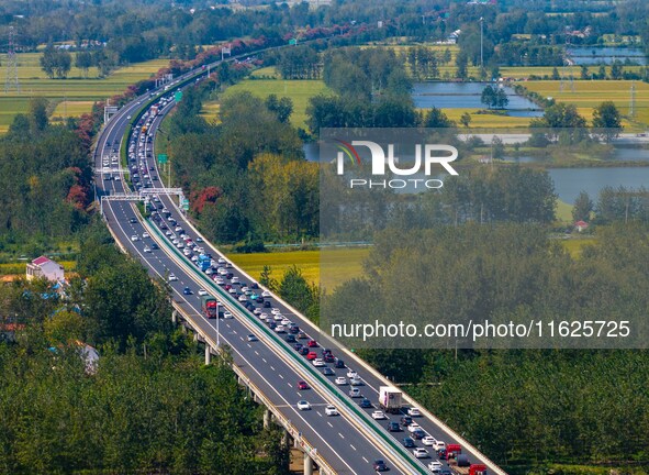 A large number of vehicles move slowly along an expressway in Huai'an, China, on October 1, 2024. 