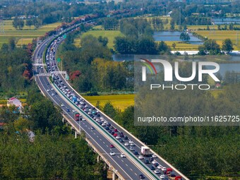 A large number of vehicles move slowly along an expressway in Huai'an, China, on October 1, 2024. (