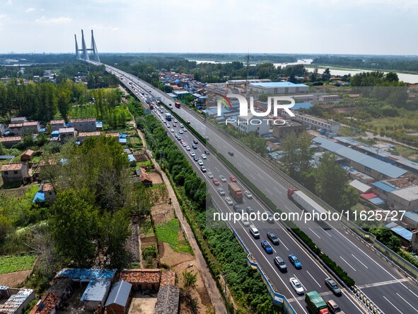 A large number of vehicles move slowly along an expressway in Huai'an, China, on October 1, 2024. 