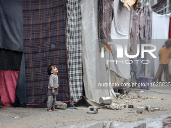 Palestinian displaced children react in front of their tent during rainfall in Deir al-Balah, central Gaza Strip, on September 1, 2024, amid...