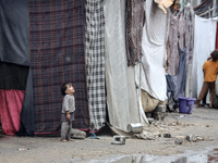 Palestinian displaced children react in front of their tent during rainfall in Deir al-Balah, central Gaza Strip, on September 1, 2024, amid...