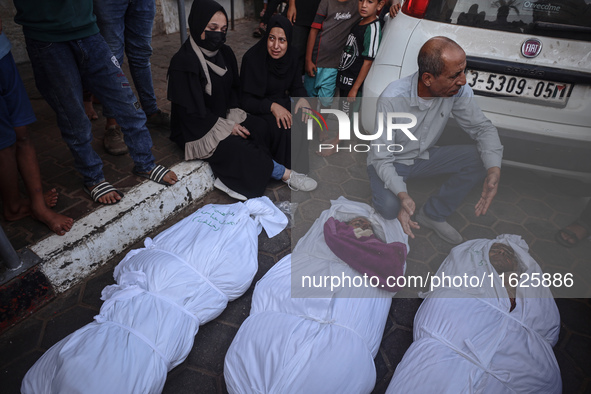 Relatives of Palestinians who are killed following the Israeli attack on the Nuseirat refugee camp mourn after the bodies are transferred to...