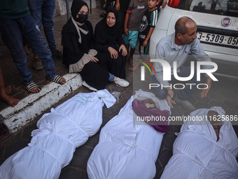 Relatives of Palestinians who are killed following the Israeli attack on the Nuseirat refugee camp mourn after the bodies are transferred to...