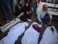 Relatives of Palestinians who are killed following the Israeli attack on the Nuseirat refugee camp mourn after the bodies are transferred to...