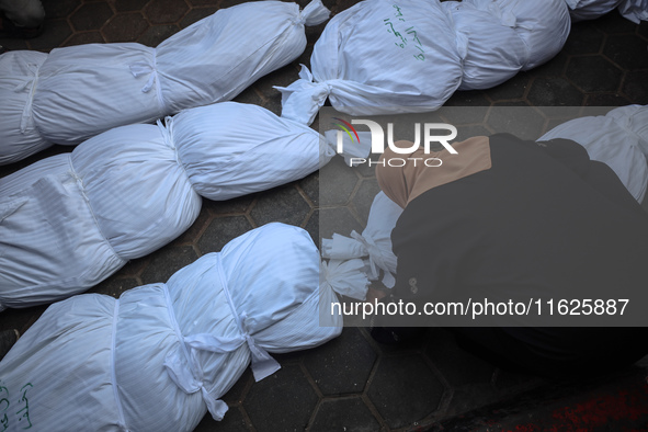 Relatives of Palestinians who are killed following the Israeli attack on the Nuseirat refugee camp mourn after the bodies are transferred to...