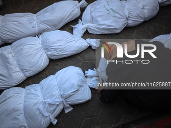 Relatives of Palestinians who are killed following the Israeli attack on the Nuseirat refugee camp mourn after the bodies are transferred to...