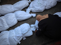 Relatives of Palestinians who are killed following the Israeli attack on the Nuseirat refugee camp mourn after the bodies are transferred to...