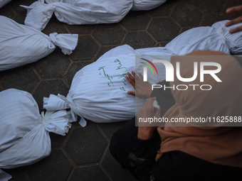 Relatives of Palestinians who are killed following the Israeli attack on the Nuseirat refugee camp mourn after the bodies are transferred to...