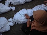 Relatives of Palestinians who are killed following the Israeli attack on the Nuseirat refugee camp mourn after the bodies are transferred to...