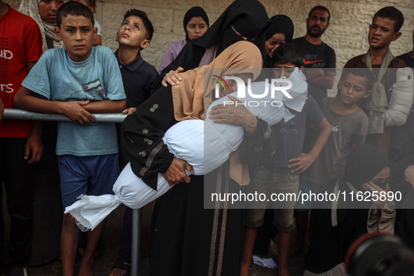 Relatives of Palestinians who are killed following the Israeli attack on the Nuseirat refugee camp mourn after the bodies are transferred to...