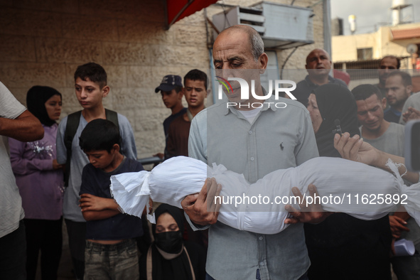 Relatives of Palestinians who are killed following the Israeli attack on the Nuseirat refugee camp mourn after the bodies are transferred to...